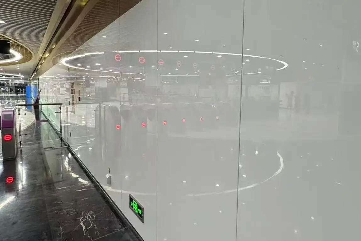 Large-format white crystallized glass wall panels in a metro station