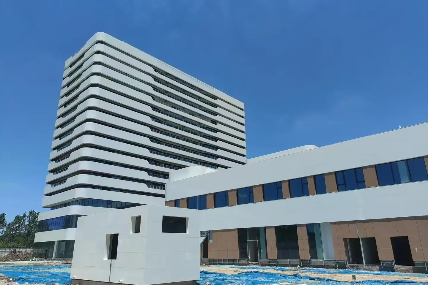 Hospital building clad in white crystallized glass horizontal facade bands