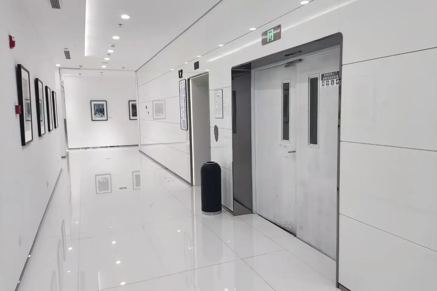 White crystallized glass wall panels lining a lift lobby