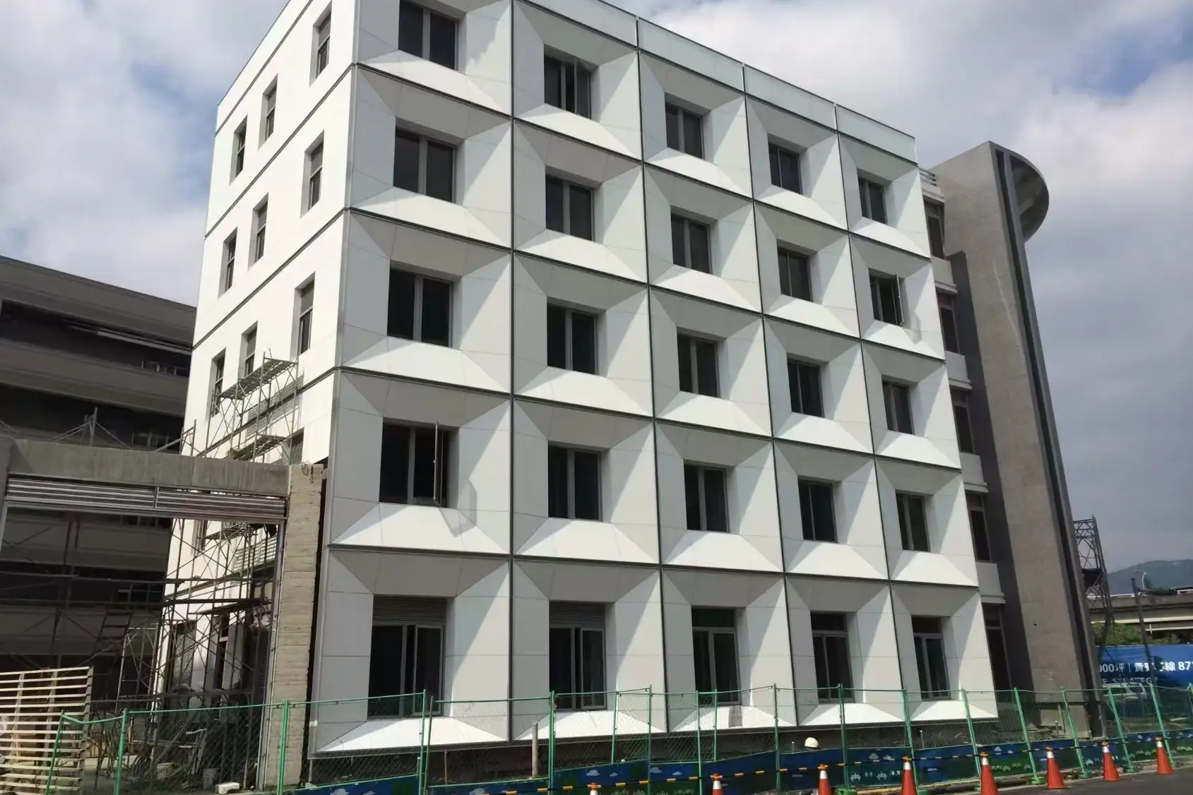 White crystallized glass panels covering a multi-storey building facade